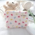 Detailed view of canvas mini pouch featuring colorful bow patterns and green hand strap - Colorful Bow
