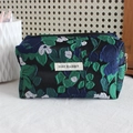 Detailed shot of black jacquard pencil case with blue floral patterns and fabric label - Navy Blue Green Flower