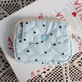 Détail de la pochette matelassée en cœur bleu clair à pois noirs avec bouton-pression - Cœur Bleu à Pois