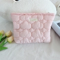 Close-up of quilted pink cloud makeup bag with brand label on soft fabric background - Makeup Bag / Pink