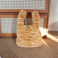 Dettaglio borsa di peluche con motivo a gatto arancione e fodera a quadretti bianchi e neri - Stampa tigrata