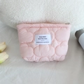 Close-up of pink quilted cloud makeup bag with zipper and logo patch on soft white faux fur - Lipstick Pouch / Pink