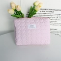 Detailweergave van de roze gewatteerde hartpatroon toilettas met wit logo en rits - Crepe Gestreepte Hart Lichtroze