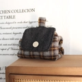 Detail der karierten Münzbörse mit blauer Denim-Klappe und weißem Knopf auf Holzregal - Gelb Braun Karo