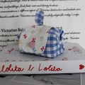 Detailed view of a mini checkered pouch with a bow-print flap and pink button closure - Blue Plaid