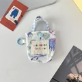 Détail d'une mini pochette en tissu floral avec clip bleu et étiquette brodée - Fleur de Galsang Bleu