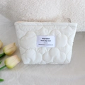 Detailed view of quilted white cloud cosmetic bag with silver zipper and fabric patch - Lipstick Pouch / Cream