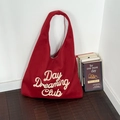 Borsa tote in lana rossa con ricamo Day Dreaming Club in un ambiente domestico - Day Rosso