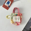 Détail d'une mini pochette florale avec poignée à carreaux rouges et crochet en plastique - Carreaux Fleuris