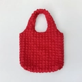Detail of red bubble texture fabric and 3D pleated design on a puff tote bag - True Red