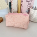 Macro view of a soft pink quilted cloud pencil case on a cozy desk with warm lighting - Quilted Cloud Pink