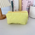 Close-up of bright green quilted cloud makeup bag on a minimalist desk with lamp - Quilted Cloud Yellow
