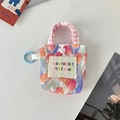 Gros plan sur la pochette fleurie tulipe avec anse à carreaux et logo brodé - Tulipe Mer de Fleurs