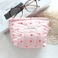 Beauty case trapuntato rosa con cuori rossi e trama morbida su tovaglia di pizzo - Cuore a Righe Trapuntate Rosa