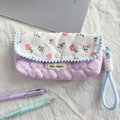 Dettaglio dell'astuccio trapuntato floreale con motivo a quadri viola e bordo con pompon - Cuore a Righe Crepe Rosa Chiaro