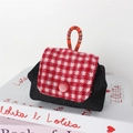 Close-up of a mini denim earphone bag with red houndstooth flap and colorful woven strap - Black Denim Plaid