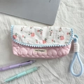 Dettaglio macro dell'astuccio trapuntato floreale con ricami a cuore e nappe blu - Cuore Trapuntato Rosa Chiaro