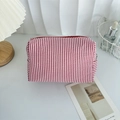 Dettaglio macro della borsa da trucco in seersucker a righe rosse e bianche con zip - Strisce rosse