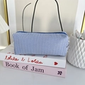 Detail view of a blue and white striped seersucker pencil case with metal zipper closure - Blue Stripe