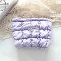 Close-up of lavender quilted makeup bag with white MAY RABBIT label on textured fabric - Bubble Grid Purple