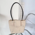 Détail du sac cabas beige en peluche avec broderies nœuds bleus et fines anses noires - Abricot Noeud Bleu