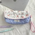Astuccio trapuntato a fiori con pom-pon rosa e chiusura a bottone accanto a un tablet - Cuore a Righe Crepe Blu
