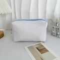 Dettaglio della borsa in tessuto waffle bianco con cerniera blu e anello di metallo - Bianco