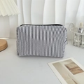 Detail of blue and white seersucker striped pouch with zipper in a cozy desk setting - Navy Stripe