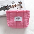Detailed macro of pink quilted nylon fabric with vertical stripes and woven brand label - Quilted Vertical Stripe Pink