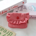 Detail view of red gingham fabric pouch with ruffled edges and button closure - Red Plaid