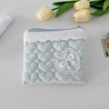 Detail of light blue quilted heart pouch featuring white lace trim and bow embroidery - Crinkle Blue Heart