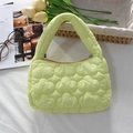 Detailed top view of light green quilted cloud handbag on a soft white fabric background - Quilted Cloud Handbag / Yellow