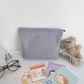 Detail of blue striped seersucker makeup bag with a smooth metal zipper closure - Navy Stripe