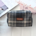 Gros plan sur la trousse de maquillage en laine à carreaux avec logo en cuir marron - Laine Plaid Gris Foncé Beige