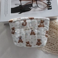 Detailed macro view of a quilted bear print makeup bag with a bow and zipper closure - Cartoon Bear