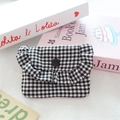 Close-up of black and white checkered fabric pouch with ruffle edge and snap button - Black Check