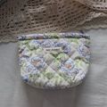 Detailed macro view of quilted floral cosmetic bag with May Rabbit label and zipper - Blue Flower