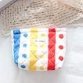 Detailed macro view of quilted floral makeup bag with colorful stripes and fabric label - Colorful Stripes and Dots