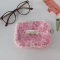 Close-up of soft pink leopard print plush coin purse with zipper and gold label tag - Pink