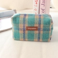 Detailansicht des karierten Strickstoffs und des Leder-Logo-Etiketts auf der Tasche - Wolle See Grün Blau Karo
