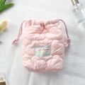 Detailed view of pink quilted camera pouch with purple drawstrings and decorative label - Quilted Cloud Pink