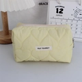 Detail of yellow quilted heart makeup bag with May Rabbit label and gold metal zipper ring - Quilted Large Heart Yellow