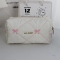 Detail of white quilted makeup bag with pink bow embroidery and metal zipper closure - Pink Embroidered Bow