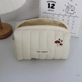 Detailed view of cream quilted makeup bag with red mushroom embroidery and soft texture - Quilted Embroidered Mushroom