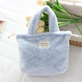 Dettaglio della borsa in peluche blu ghiaccio con etichetta tessuta e manici in ecopelliccia - Blu