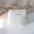 Detailed view of white quilted square makeup bag with soft textured fabric and brand label - Quilted Pleated Beige White