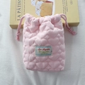Detail view of pink heart-quilted drawstring storage bag with soft protective padding - Pink Crepe Heart