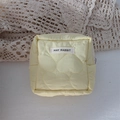 Detail of light yellow quilted makeup bag with heart stitching and logo label - Quilted Large Heart Yellow