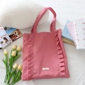 Détail du sac cabas à carreaux rouges avec bords à volants et étiquette tissée - Plaid Rouge