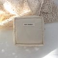 Close-up of heart-shaped quilted pattern and woven label on cream cosmetic bag - Quilted Large Heart Beige White